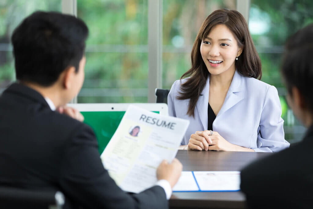 A recruiter holding a resume while interviewing an applicant.